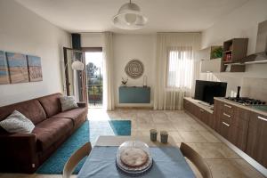ein Wohnzimmer mit einem Sofa und einem Tisch in der Unterkunft Il Piccolo Albero in Scardovari