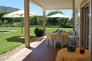 eine Terrasse mit einem Tisch, Stühlen und Sonnenschirmen in der Unterkunft Casa do Castanheiro in Reboreda