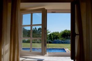 ein offenes Fenster mit Poolblick in der Unterkunft Casa do Castanheiro in Reboreda