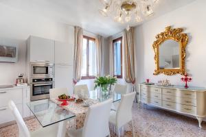 comedor con mesa de cristal y armarios blancos en Appartamento Perla con vista Canale, en Venecia 20 fotos más