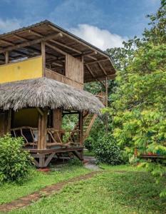 a hut with a straw roof and a table at Maracumbo Lodge in Mompiche