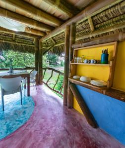 jadalnia w domu ze stołem i krzesłami w obiekcie Maracumbo Lodge w mieście Mompiche