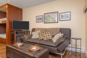 uma sala de estar com um sofá e uma televisão em East Condo #202 em Girdwood