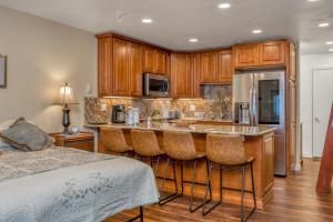 a kitchen with a bar with stools next to a bed at East Condo #202 in Girdwood