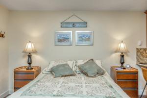 a bedroom with a bed with two night stands and two lamps at East Condo #202 in Girdwood