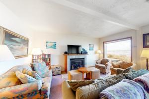 a living room with two couches and a fireplace at The Hideout in Rockaway Beach