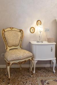 una silla y una mesa auxiliar con una lámpara. en Appartamento Perla con vista Canale, en Venecia