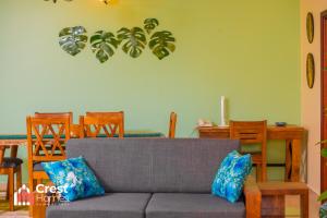 a living room with a couch and a dining room table at Crest Homes Uganda in Kitende