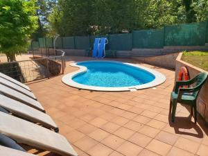 una pequeña piscina en un patio con un banco en Apartamentos la Francesa en Santa Pau