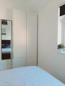 a white bedroom with a bed and a closet at Cosy 1 Bedroom Apartment in the Heart of Llandudno in Llandudno