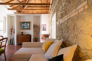 uma sala de estar com uma parede de pedra e um sofá em IV Casale Roma Country Villa em Prima Porta