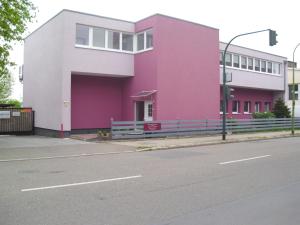 ein rosa und weißes Gebäude an der Straßenseite in der Unterkunft Casa Rose in Essen