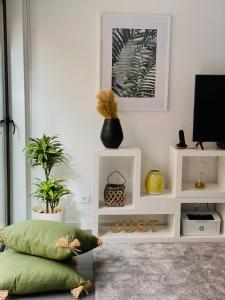 a living room with a green pillow and a tv at InSide Furnas in Furnas