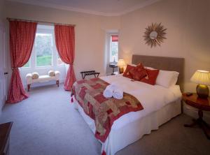 a bedroom with a large bed and a large window at Craigellachie Lodge in Craigellachie