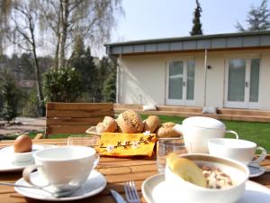 a wooden table with plates of food and cups on it at Boutique Hotel Villa Katharina in Bamberg