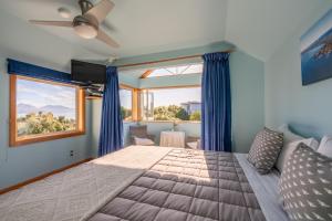 um quarto com uma cama grande e uma janela grande em Nikau Lodge em Kaikoura