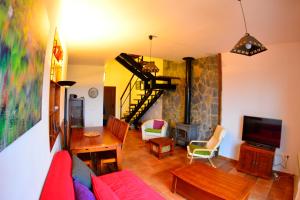 sala de estar con sofá rojo y TV en Casa Suber, en Aracena