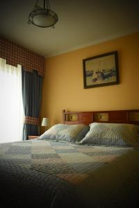 1 dormitorio con 1 cama y una foto en la pared en Hotel Doria, en Rancagua