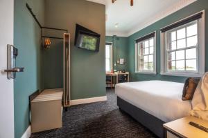 PymbleNightcap at Pymble Hotel的一间卧室设有绿色的墙壁、一张床和一张书桌