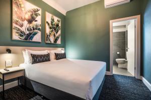 a bedroom with a large bed and a bathroom at Nightcap at Pymble Hotel in Pymble