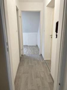 an empty room with a hallway with wood floors at Apartment für Monteure Nr 4 in Kassel