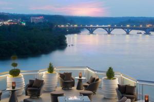 a balcony with chairs and a view of a river at The Watergate Hotel Georgetown in Washington