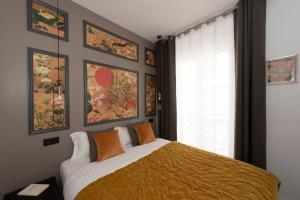 a bedroom with a large bed with orange pillows at Arigato in Paris