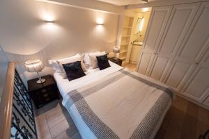 パリにあるFenetre sur Courのベッドルーム1室(大型ベッド1台、白いシーツ、枕付)