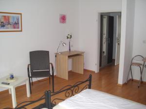 Schlafzimmer mit einem Bett, einem Schreibtisch und einem Stuhl in der Unterkunft Casa Rose in Essen