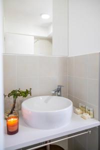 a white sink in a bathroom with a candle at Toi et Moi Apartments-Guests speek for us! in Ponta Delgada