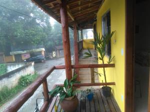 a balcony of a house with potted plants on it at Suites da Dorinha in Visconde De Maua