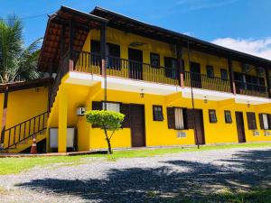 ein gelbes Gebäude mit einem Baum davor in der Unterkunft Pousada Casa Do Mar in Paraty