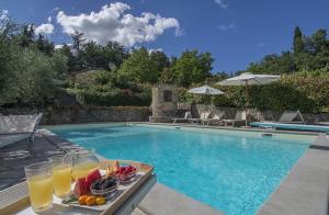 una bandeja de fruta en una mesa junto a la piscina en Villa Flora en Fondaccio