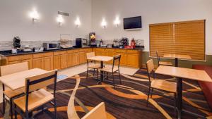 a room with tables and chairs and a kitchen at Best Western Rayne Inn in Rayne