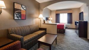 a hotel room with a couch and a bed at Best Western Dayton Inn & Suites in Dayton