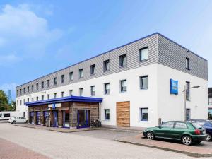 a building with a green car parked in front of it at ibis budget Flensburg Handewitt in Handewitt