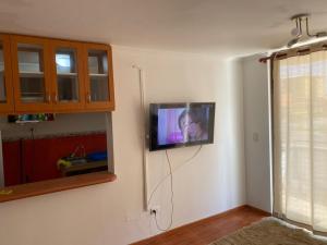 a television hanging on a wall in a room at Departamento amoblado por día in Arica