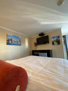 a bedroom with a bed and a flat screen tv at Relax Inn North Babylon in North Babylon