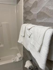 een badkamer met witte handdoeken en een bad bij Relax Inn North Babylon in North Babylon