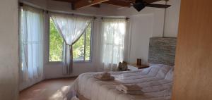 Schlafzimmer mit einem großen Bett vor den Fenstern in der Unterkunft AMANU Casa Unica en el delta de Tigre a solo 5' para 25 personas in Tigre