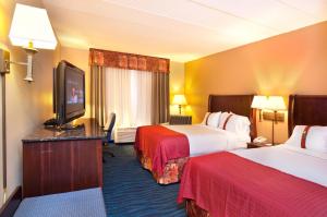 a hotel room with two beds and a flat screen tv at Holiday Inn Hotel & Suites Council Bluffs, an IHG Hotel in Council Bluffs