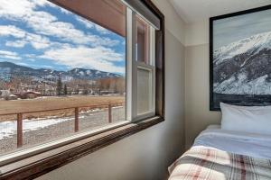 a bedroom with a window with a view of snow covered mountains at Loyal Duke Lodge in Salida
