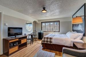 a hotel room with a bed and a flat screen tv at Loyal Duke Lodge in Salida
