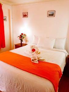 Un dormitorio con una gran cama blanca con una flor. en Hostal Tu Hogar, en Cusco