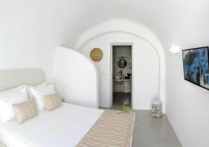 Postel nebo postele na pokoji v ubytování Golden Stone Santorini Suites