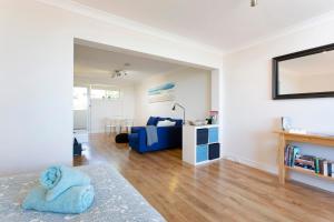 a living room with a blue couch and a table at Fremantle Sunset Studio Rottnest Island Views in Fremantle