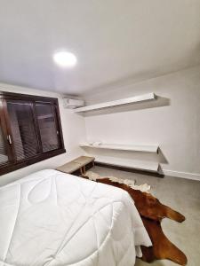 - une chambre avec un lit blanc dans l'établissement Apartamento Artístico - Garagem - Ar Condicionado - Excelente Localização, à Bento Gonçalves