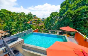 una piscina con sombrilla naranja y sombrilla naranja en Bali Ubud Harmony, en Ubud
