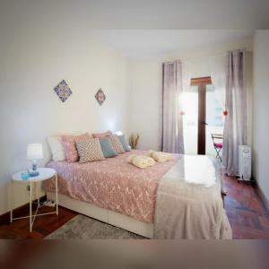 ein Schlafzimmer mit einem großen Bett und einem Tisch in der Unterkunft Cozy Apartment Alegria Balcony in Porto