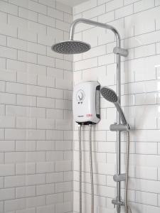 a shower with a shower head in a bathroom at Khampare Chiang Mai Hotel in Chiang Mai